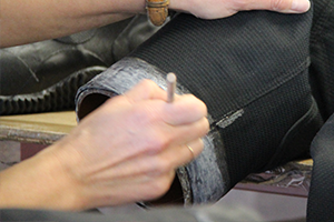 Detail view of seam replacement process on a military drysuit